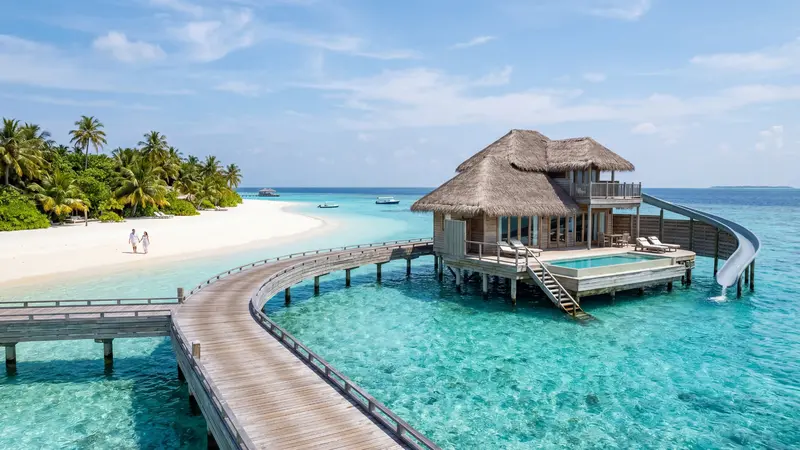 Maldives overwater villa on a turquoise lagoon with white sand beach
