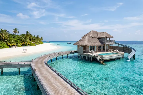 Maldives overwater villa on a turquoise lagoon with white sand beach